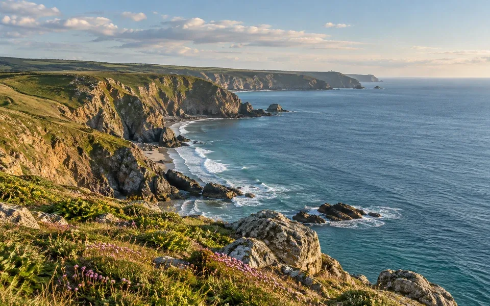 A coastal headland with cliffs, shoreline and open water.